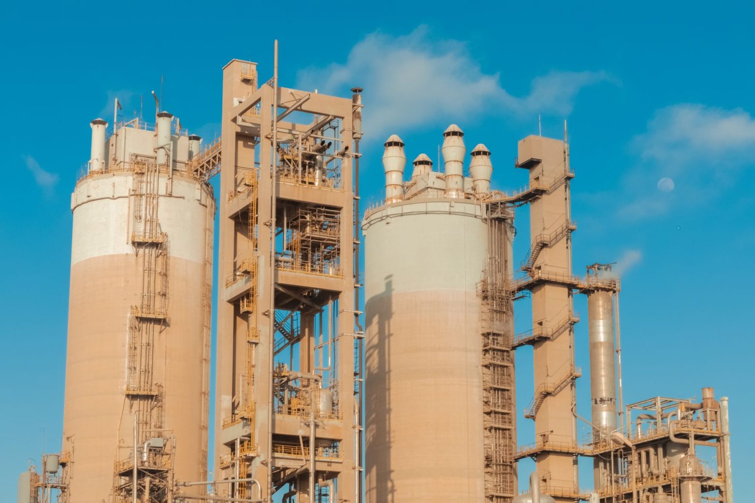 Torres de ureia em uma planta industrial de produção de fertilizantes sob céu claro.