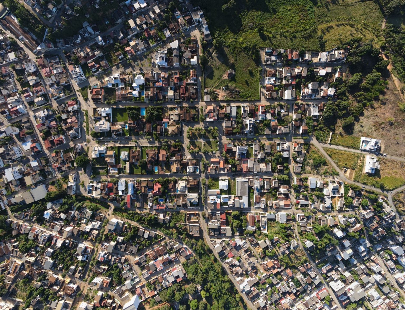 Corumbá adere ao AdaptaCidades para elaborar plano de adaptação climática Vista aérea de uma área urbana brasileira, com ruas, edificações e áreas verdes ao redor.